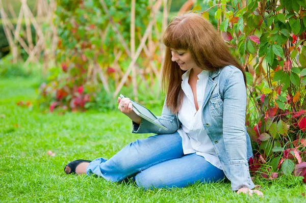 Ung kvinna läser i TabletPC — Stockfoto