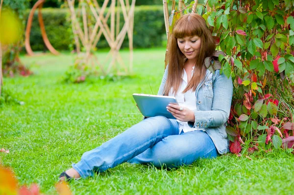 Молода жінка читає в планшетному ПК — стокове фото