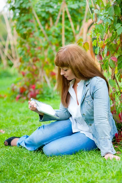 Молодая женщина, читающая на планшете ПК — стоковое фото