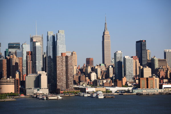 New York City skyline with the Empire State Building and the many boats docked on the Hudson River.