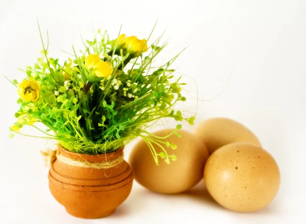 Velikonoce - vajíčka a keramická váza s květinami — Stock fotografie