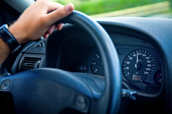 stock image Male driver with hand on wheel inside car