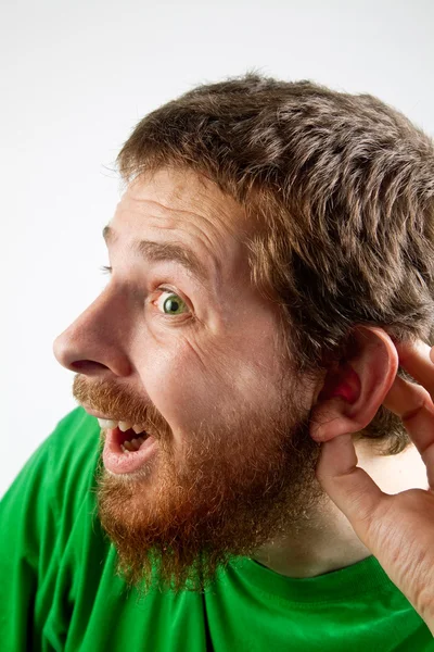 Escucha - curioso hombre divertido con la mano en la oreja — Foto de Stock