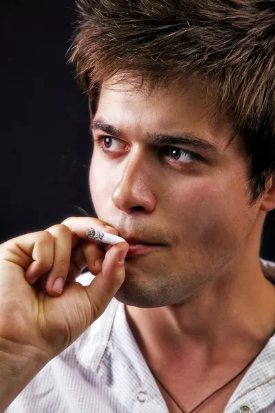 Молодой красивый мужчина курит — стоковое фото