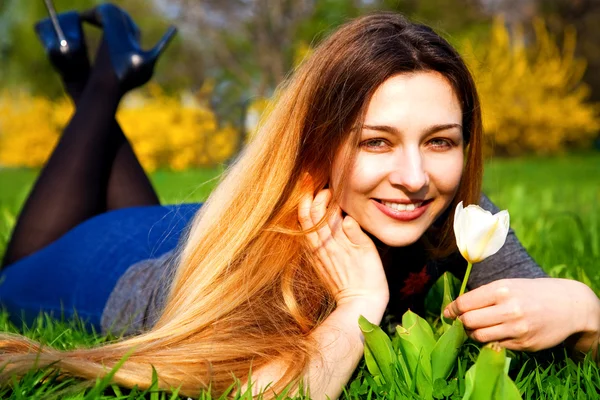 Счастливая беззаботная женщина с цветами и травой — стоковое фото
