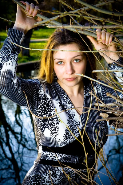 Bella donna bionda dietro i rami degli alberi — Foto Stock