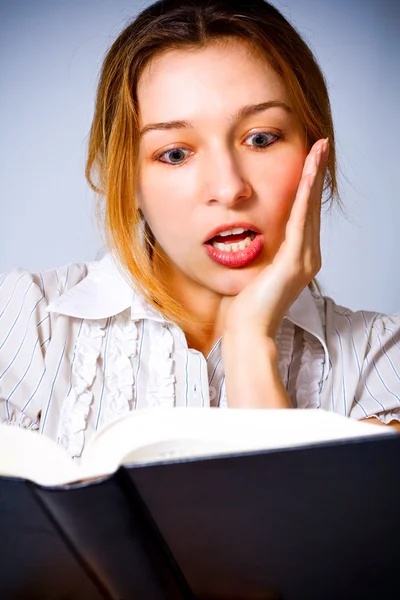 Młoda kobieta zaskoczony przez co to czytanie — Zdjęcie stockowe