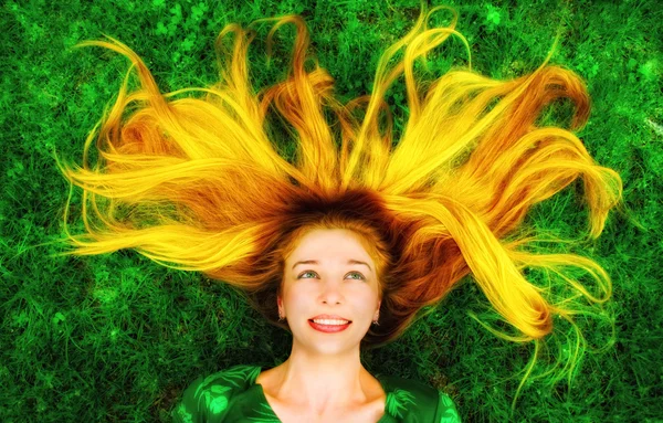 草の上のダウン長い髪と幸せな女 — ストック写真