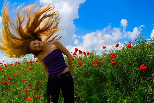 Женщина с движущимися волосами в маковом поле — стоковое фото