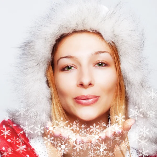 Weihnachten - glückliche Frau bläst Schneeflocken — Stockfoto