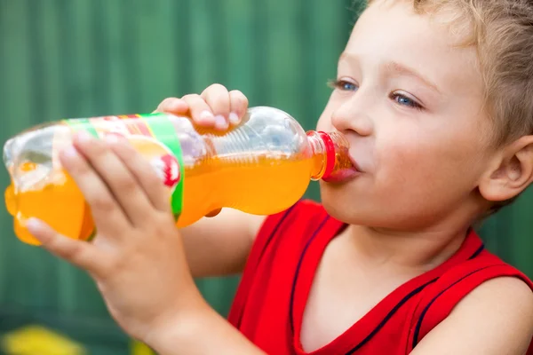 Niño bebiendo refresco embotellado poco saludable — Foto de Stock