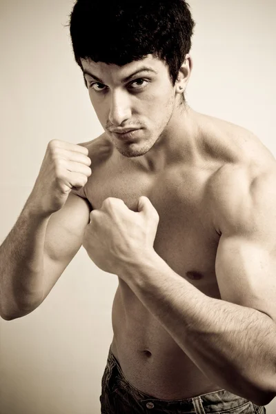 М'язистий чоловічий боєць з кулаками готовий ударити — стокове фото