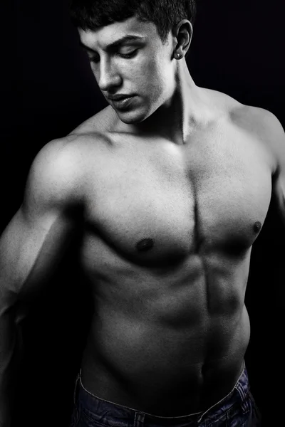 Muskulöser junger Mann im Dunkeln — Stockfoto