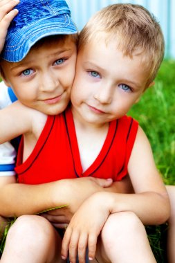 Hug of two cute brothers outdoor clipart