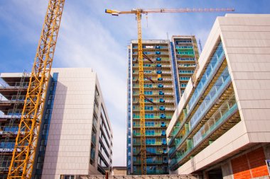 Scaffolds and cranes at construction site clipart