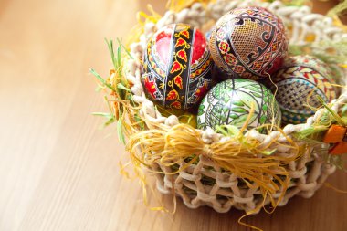 Easter painted eggs in traditional basket clipart