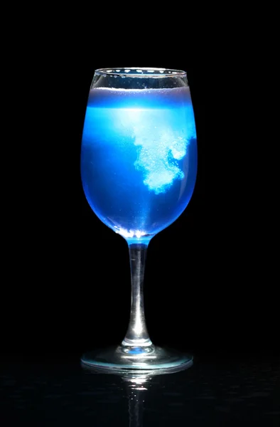 Isolated glass with blue splashing beverage — Stock Photo, Image