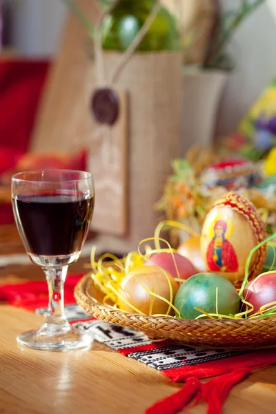 Uova dipinte di Pasqua e bicchiere di vino sul tavolo — Foto Stock
