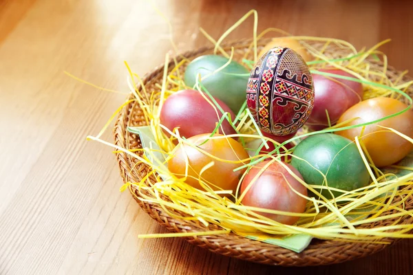 Великодні розмальовані яйця в традиційному кошику — стокове фото