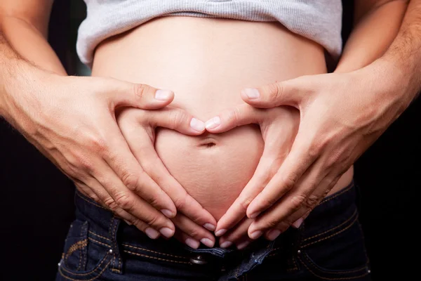 Älska händerna på gravid kvinna och man — Stockfoto