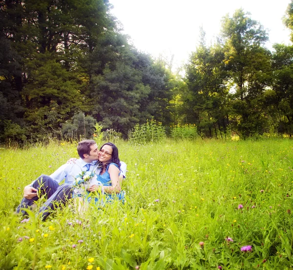 Beijo de amantes românticos na grama verde — Fotografia de Stock
