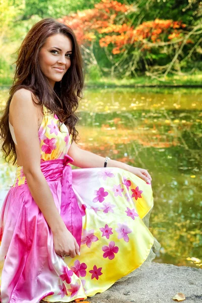 Vrouw met mooie kleurrijke jurk in de buurt van lake — Stockfoto