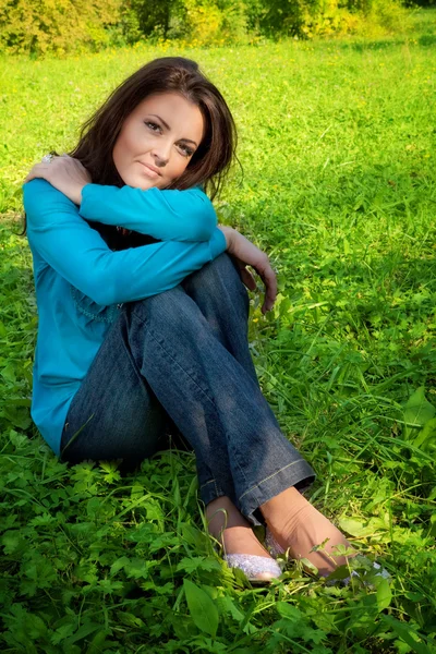 Serena bela mulher descansando na grama verde — Fotografia de Stock