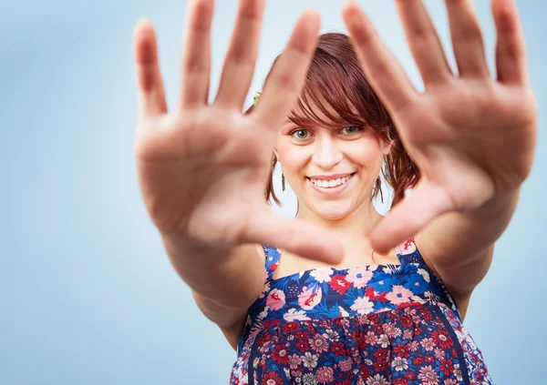 Šťastný hravé dospívající žena dívá skrze ruce — Stock fotografie