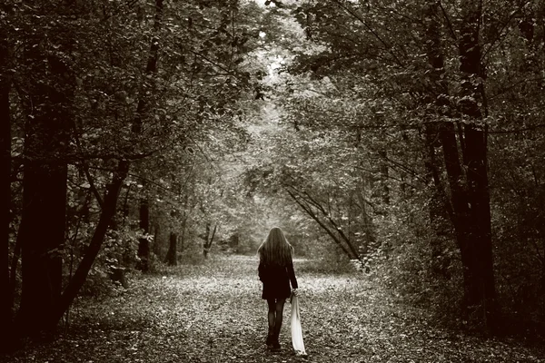 Mujer triste y solitaria en el camino del bosque Imagen de archivo