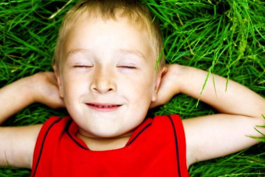 Happy dreaming child on fresh grass clipart