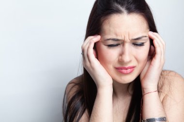 Headache concept - woman suffering a migraine clipart