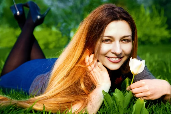 Feliz joven mujer y flor en hierba fresca — Foto de Stock