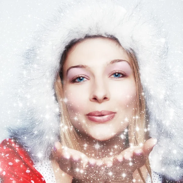 Glückliche Winterfrau, die Schneeflocken bläst — Stockfoto