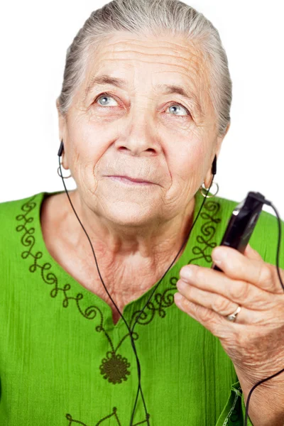 Mujer mayor escuchando música en el teléfono móvil — Foto de Stock