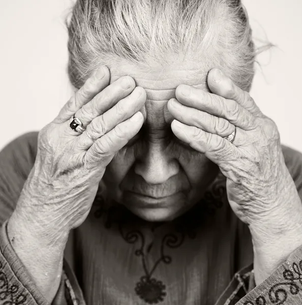 Сумна стара старша жінка з проблемами зі здоров'ям — стокове фото