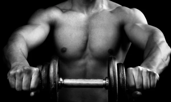 Сильный мускулистый мужчина держит гантель — стоковое фото