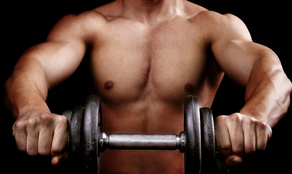 Potente hombre musculoso sosteniendo el peso del entrenamiento — Foto de Stock