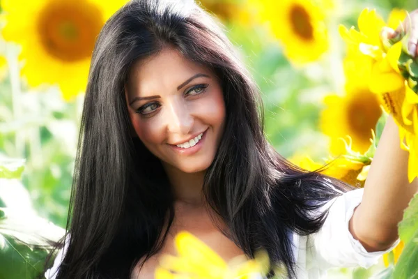 Glückliche Frau im Sonnenblumenfeld — Stockfoto