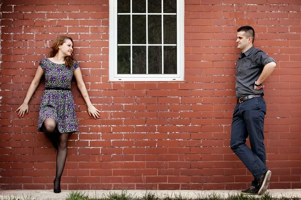 Gelukkige paar en huis met bakstenen muur — Stockfoto