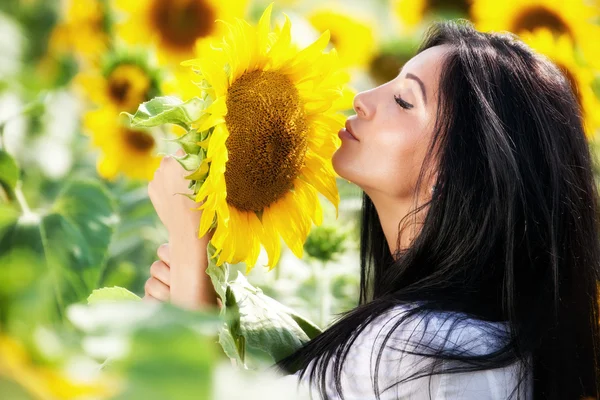 Jonge vrouw in zonnebloem veld — Stockfoto