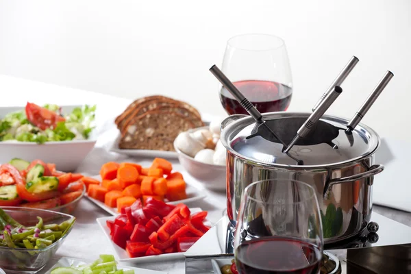 Stół z zestawem fondue i składnikami — Zdjęcie stockowe