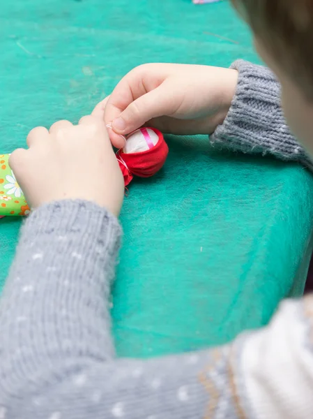 Het kind maakt een traditionele speelgoed uit verschillende lompen — Stockfoto