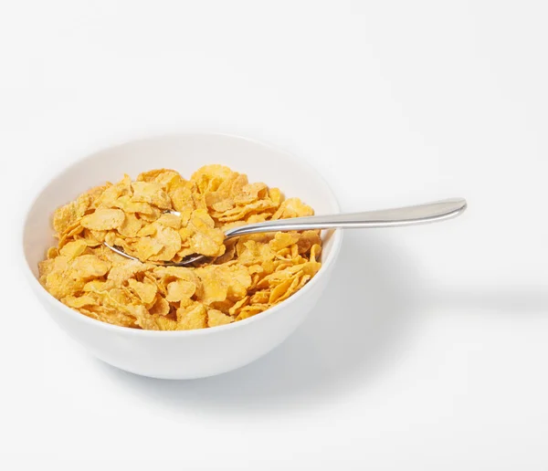 Corn flakes in deep plate with spoon.A Breakfast. High key. — Stock Photo, Image