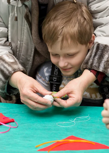 Eltern helfen Kindern, traditionelles Spielzeug aus Lumpen herzustellen — Stockfoto