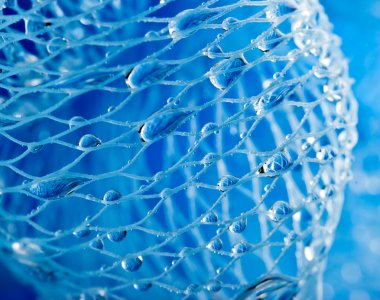 Abstract macro photo of massage blue bath sponge with water drops. clipart