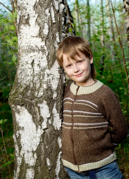 Sorrindo menino bonito na floresta de primavera — Fotografia de Stock