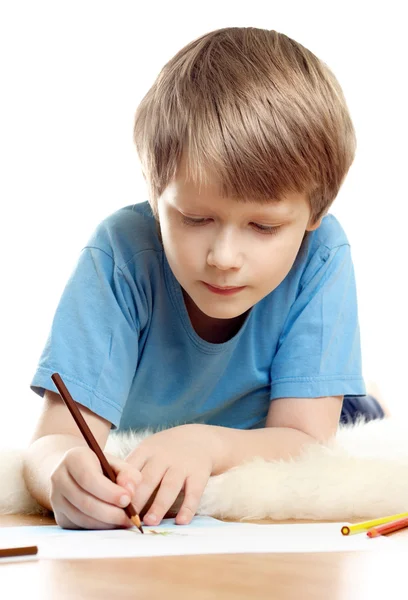 Lindo niño soñador miente y dibujar en piel de oveja suave aislado sobre bac blanco — Foto de Stock
