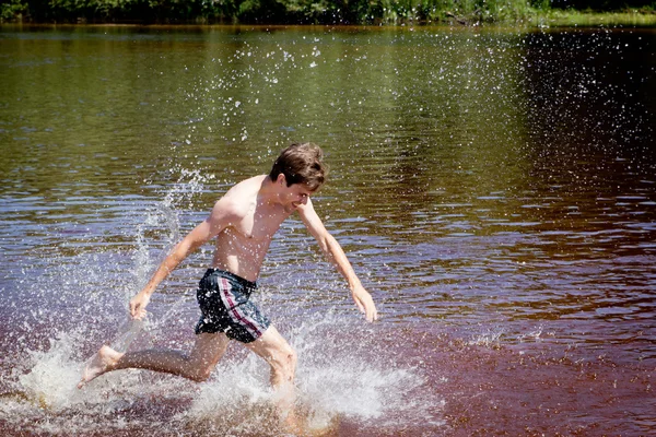 Man having fun running through the water in the river water in summer. — Stock Photo, Image