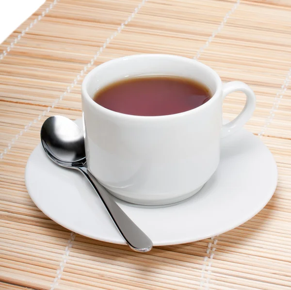Tasse schwarzen Tee mit Löffel auf Serviette isoliert über weißem Hintergrund. — Stockfoto