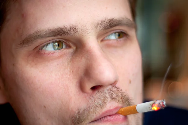 Мужчина средних лет курит сигарету в баре. Сосредоточься на глазах . — стоковое фото